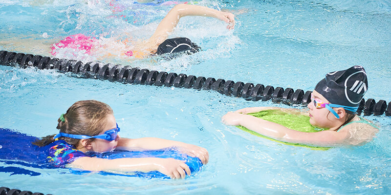 Narwhals swimmers practicing with kickboards in a lane