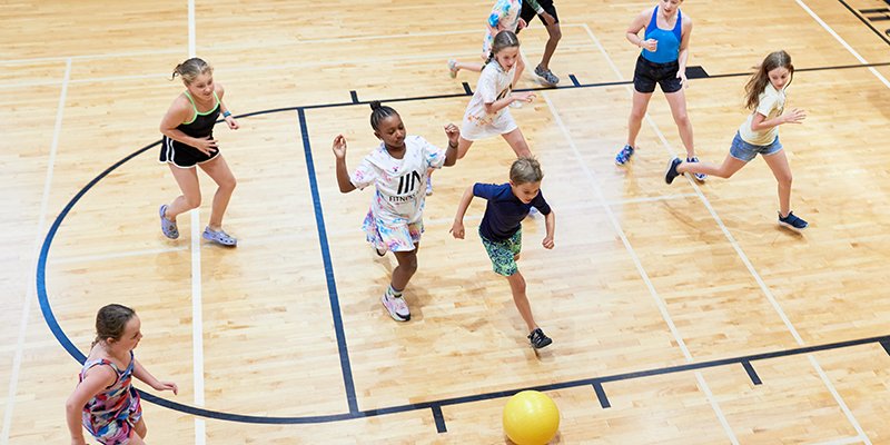 Campers running and playing ball in the gym
