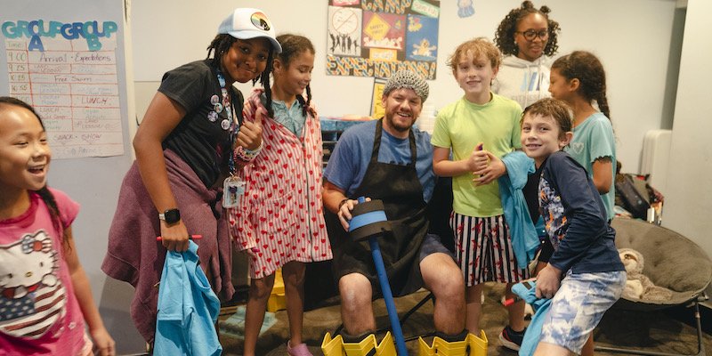 Campers and a counselor laughing together in the camp room